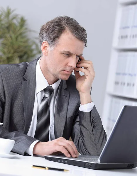 Uomo d'affari che fa conversazione telefonica sul posto di lavoro — Foto Stock