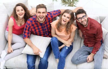 dört mutlu arkadaş kanepede otururken gülüyor