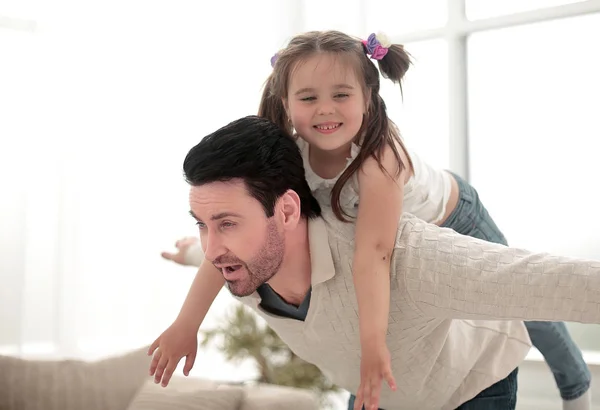 Счастливый отец играет с дочерью в светлой гостиной — стоковое фото