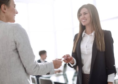 İki başarılı iş kadını kartvizitlerini paylaşıyorlar.