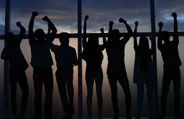 Feliz equipo de negocios de pie junto a la ventana — Foto de Stock