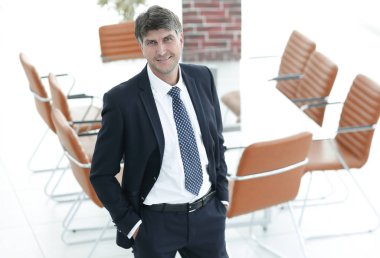 Bir boş toplantı odasında duran iş adamı