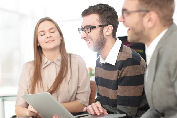 Tres empleados felices trabajando en línea con una tableta — Foto de Stock