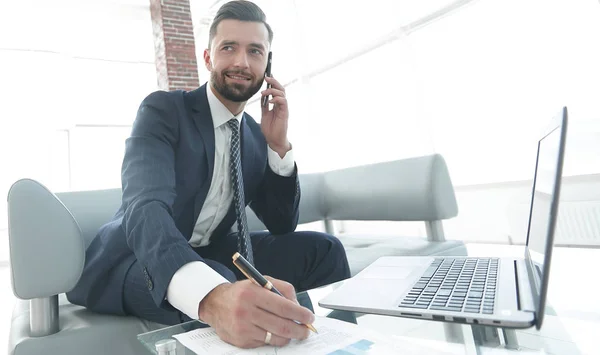 Affärsman som talar på smartphone om finansiella dokument — Stockfoto