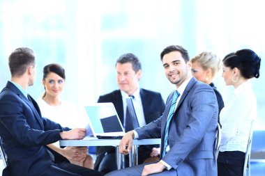 grup gülümseyen iş adamları bir toplantı odasında oturuyor.