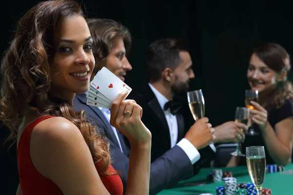 Mulher na mesa de roleta segurando copo de champanhe no cassino — Fotografia de Stock