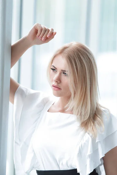 Mujer de negocios moderna sentada cerca de la ventana en la oficina . —  Fotos de Stock