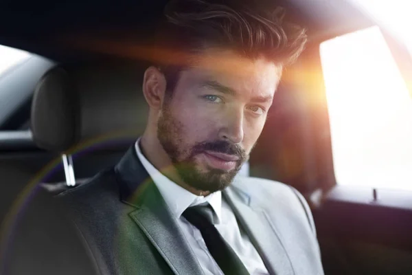 Uomo d'affari in abito elegante sul sedile posteriore dell'auto — Foto Stock