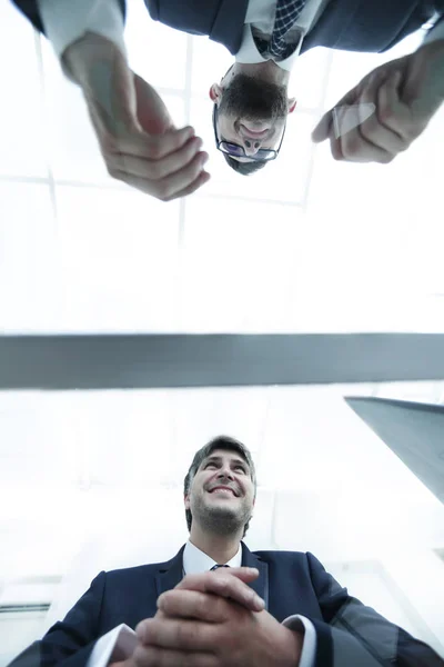 View from below. From behind the glass. Two businessmen sitting at the table.