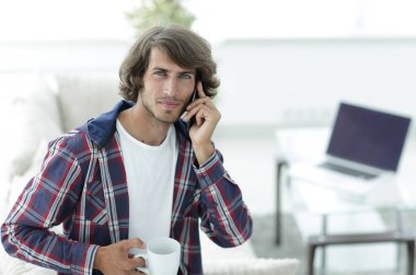 güzel bir fincan adamla bir dizüstü bilgisayar önünde oturur.