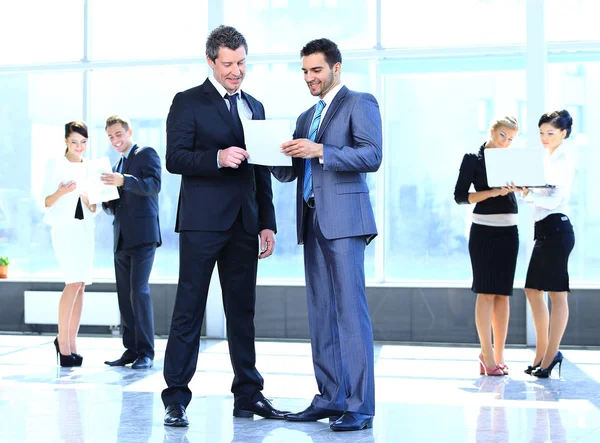 Medewerkers bespreken working papers permanent in de lobby — Stockfoto