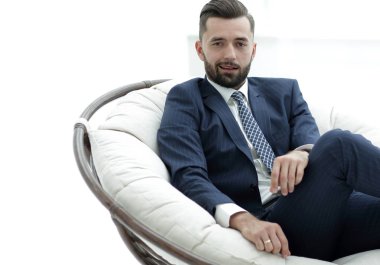Kendine güvenen işadamı bir sandalyede oturuyor