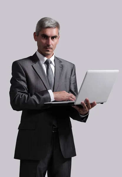 Empresário de pé com um laptop aberto — Fotografia de Stock
