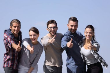 başparmak gösterilmesini gençlerin grup gülümseyen.
