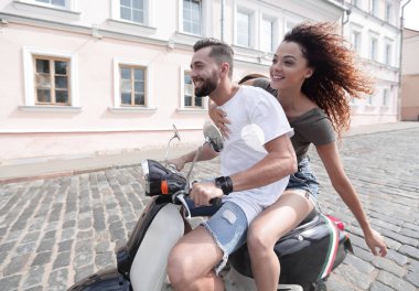 mutlu genç bir çift bir scooter üzerinde eğleniyor