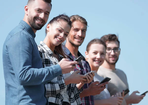 Gruppe junger Menschen mit modernen Smartphones. — Stockfoto