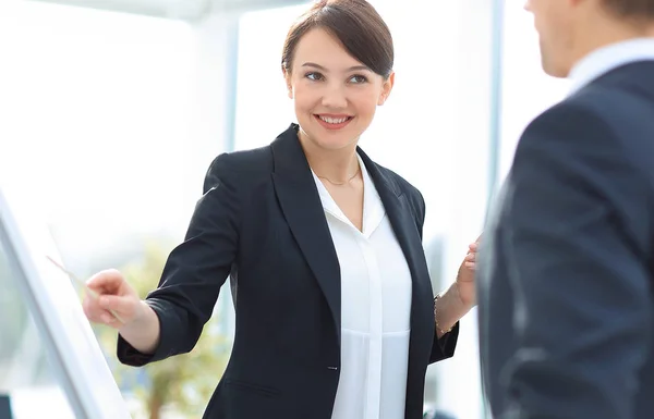 Geschäftsfrau zeigt einem Geschäftsteam Informationen auf dem Flipchart — Stockfoto