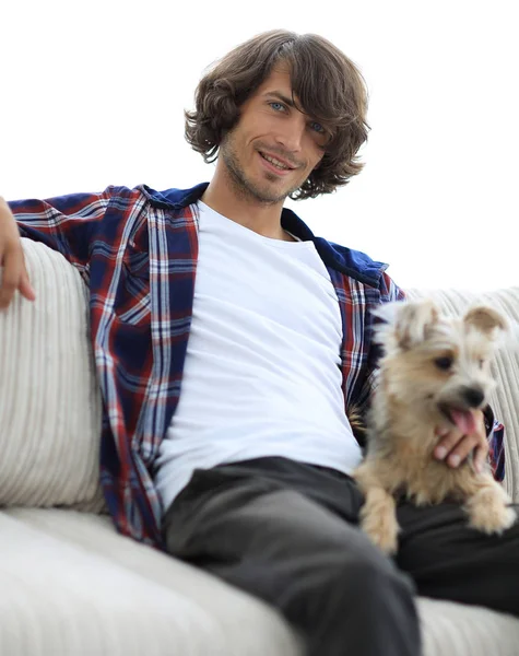 Tipo elegante sentado en el sofá con su perro . — Foto de Stock