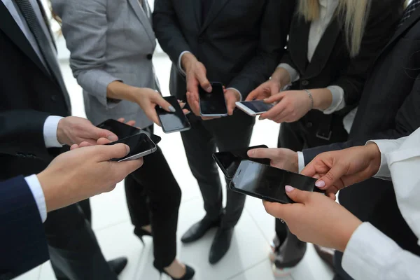 Primer plano de los teléfonos inteligentes en manos de los jóvenes de negocios — Foto de Stock