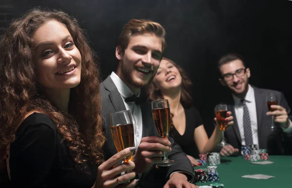Grupo de amigos sentados à mesa de jogo no casino — Fotografia de Stock