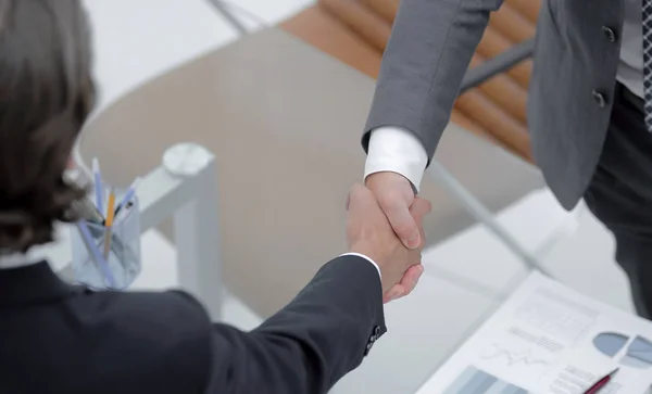 Handslag för affärspartners som sitter vid sina skrivbord — Stockfoto