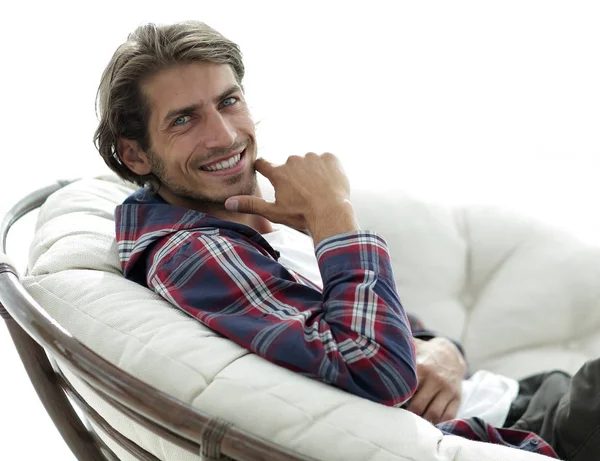 Primer plano. el chico está descansando sentado en una silla grande y cómoda . — Foto de Stock