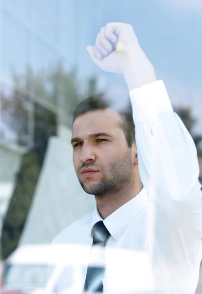 view from behind glass.confident businessman looking out the window of his office