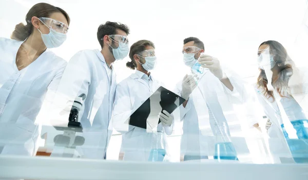 Forskare som arbetar med provrör och mikroskopet i laboratoriet — Stockfoto