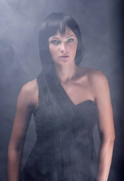 Mystisk porträtt av en flicka i mörker, i dimman — Stockfoto