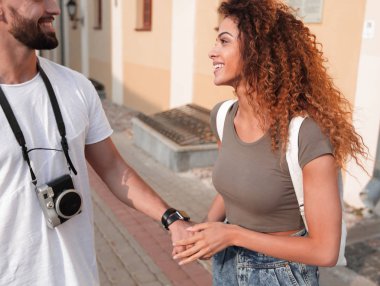 Gülümseyen mutlu turistler yürüyor ve manzaranın tadını çıkarıyor