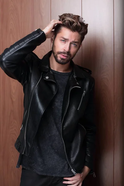 Retrato de joven guapo hombre de moda contra la pared de madera. —  Fotos de Stock