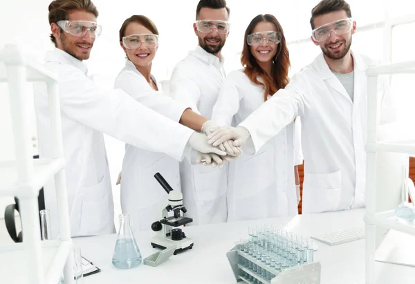 Успешная команда молодых ученых с руками, скрепленными вместе . — стоковое фото