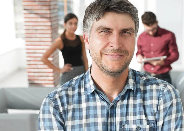 Hombre de negocios casual con los brazos cruzados de pie en la oficina — Foto de Stock