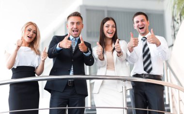 İş ekibi terasta dikiliyor ve başparmağını kaldırıyor..