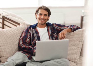 dizüstü bilgisayarda çalışan ve kameraya bakarak başarılı adam. Yukarıdan görüntülemek