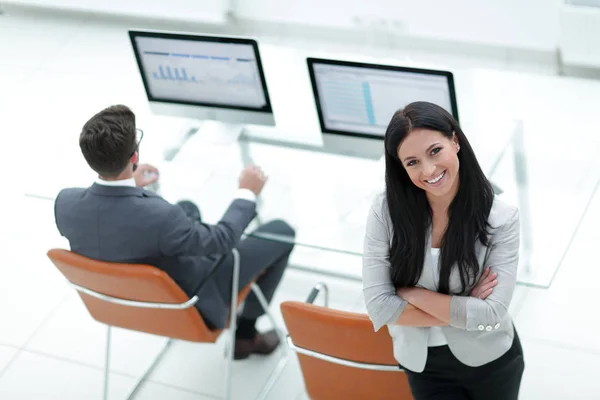 Mujer de negocios exitosa de pie cerca del lugar de trabajo moderno — Foto de Stock