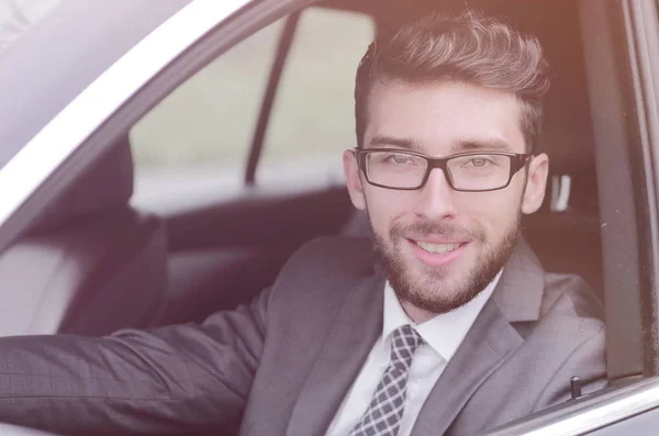Uomo d'affari in giacca e cravatta guida la sua auto di lusso . — Foto Stock