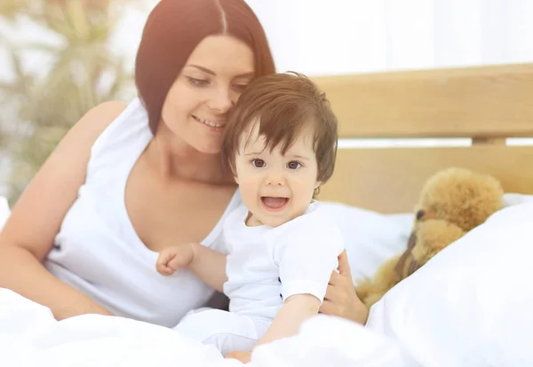 Güzel bir anne ile bebeği yatak odasında portresi — Stok fotoğraf