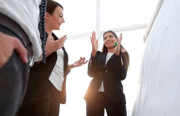 Mujer de negocios señalando con un marcador en el rotafolio — Foto de Stock