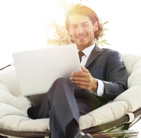 Úspěšný podnikatel s notebookem sedět v velké pohodlné armchai — Stock fotografie