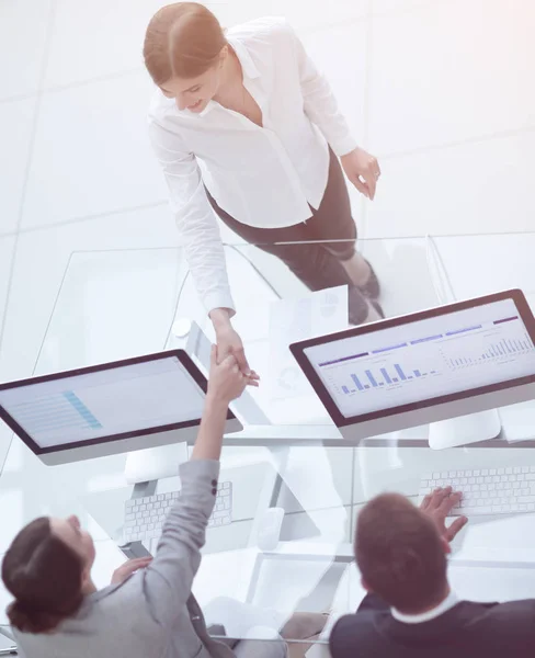 Vista desde la parte superior. handshake Gerente y empleado a través del escritorio —  Fotos de Stock