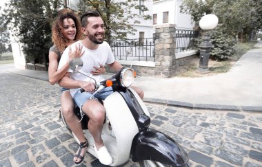 Şık genç çift bir scooter sokakta oturuyor..