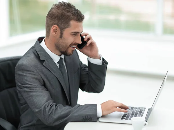 Gros plan. Homme d'affaires travaillant sur ordinateur portable et parlant au téléphone — Photo