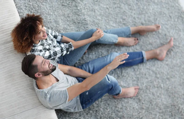 yeni bir oturma odasında bir halı üzerinde oturan yeni evli çift