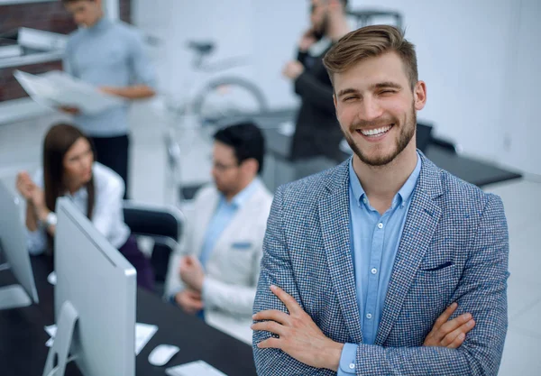 Joven empresario sonriente en el fondo de la oficina —  Fotos de Stock