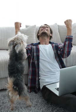 geniş oturma odasında Skordan dizüstü bilgisayar ile mutlu adam.