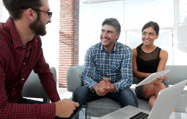 Yöneticiler Office dizüstü bilgisayar ile oturup gülümseyen portresi