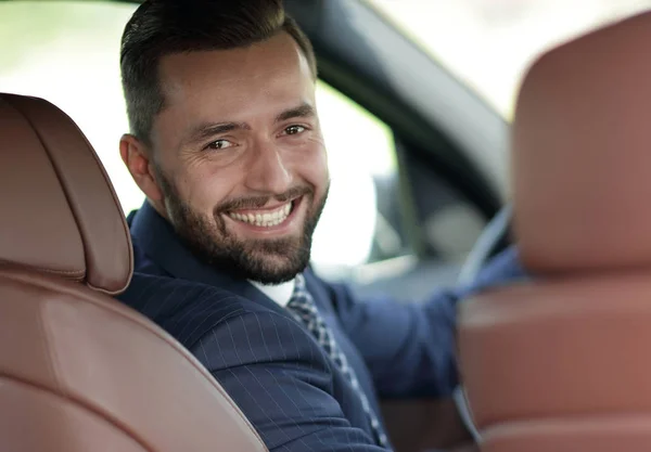 Close-up of a businessman sitting at the wheel of a car — Stock Photo, Image