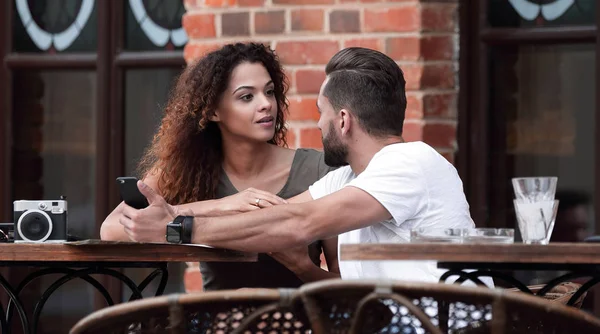 Porträt eines jungen Paares, das sich auf eine Caféterrasse setzt — Stockfoto