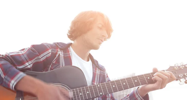 Man zingt een lied en speelt gitaar, zittend op de Bank. — Stockfoto